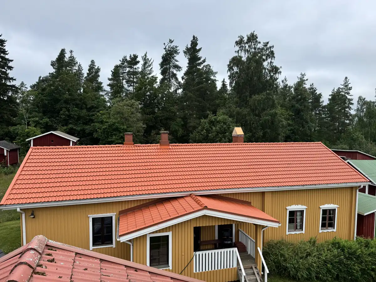 Keltainen talo ja pinnoitettu tiilikatto Kangasalla